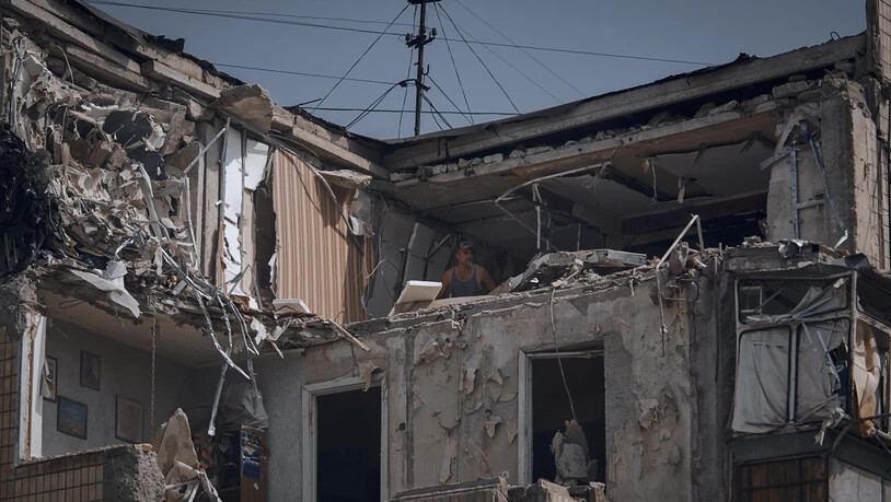 Ein Mann reinigt eine nach russischem Beschuss zerstörte Wohnung. Foto: Kostiantyn Liberov/AP/dpa