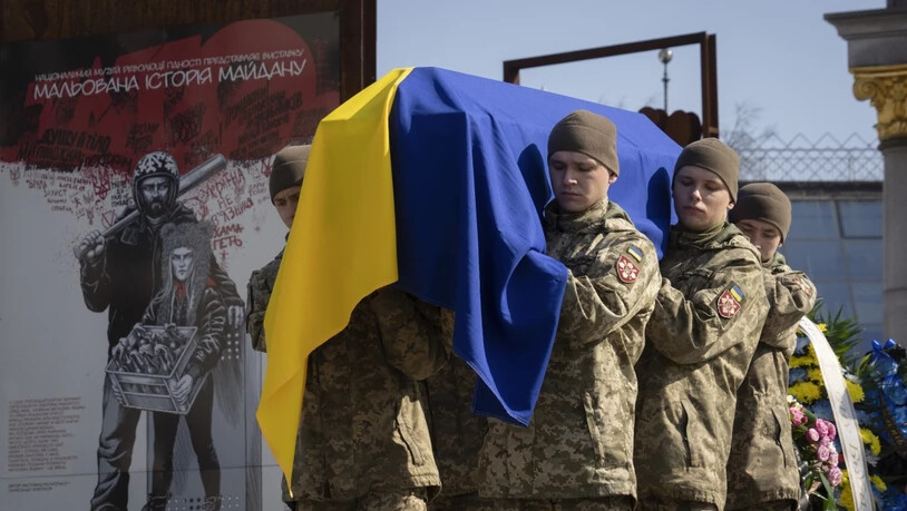 Der Sarg des freiwilligen Soldaten Bischan Scharopow wird über den Unabhängigkeitsplatz in Kiew getragen. Foto: Efrem Lukatsky/AP/dpa
