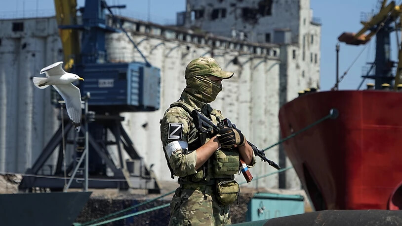 ARCHIV - Ein russischer Soldat bewacht einen Pier mit einem Getreidespeicher im Hintergrund auf dem Gelände des Seehafens von Mariupol, der nach schweren Kämpfen wieder in Betrieb genommen wurde. Foto: Uncredited/AP/dpa