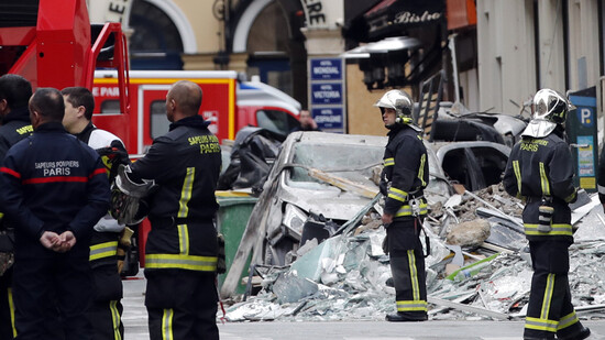ARCHIV - Feuerwehrleute stehen in der Nähe des Unfallortes einer Gasexplosion in einer Pariser Bäckerei. Drei Jahre nach der schweren Explosion mit vier Toten und Dutzenden Verletzten sollen die Opfer eine Entschädigung bekommen. Paris wolle 20 Millionen…