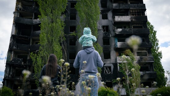 Eine Familie blickt auf ein zerstörtes Gebäude in Borodyanka. Foto: Dominic Chiu/SOPA Images via ZUMA Press Wire/dpa