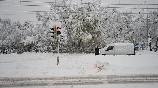 Ein Mann räumt Schnee von der Windschutzscheibe seines Fahrzeugs. Schnee und Eis haben im Süden Bayerns auf den Straßen und bei der Bahn für Chaos gesorgt. Foto: Lukas Barth/dpa