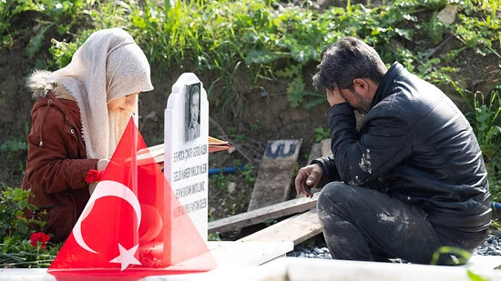 Trauernde beten am Grab eines Familienmitglieds auf einem Friedhof in Antakya. Foto: Boris Roessler/dpa