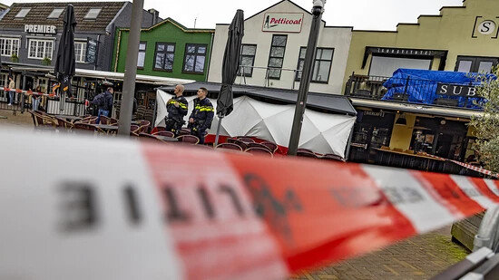 Flatterband der Polizei sperrt den Bereich rund um das Café ab, während im Gebäude Spuren gesichert werden. Foto: Christoph Reichwein/dpa