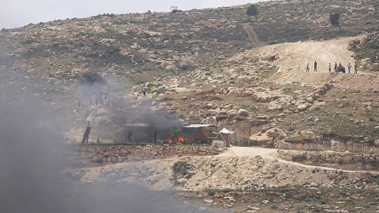 Israelische Siedler versammeln sich in der Nähe von brennenden Häusern palästinensischer Dorfbewohner. Nach dem Tod eines 14-Jährigen aus einer israelischen Siedlung kam es erneut in verschiedenen Orten des Westjordanlandes zu gewalttätigen Angriffen…