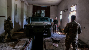 Soldaten bereiten sich mit einem gepanzerten Fahrzeug mit aufmontierten Maschinengewehren auf den Einsatz an der Front vor. Foto: Rick Mave/SOPA Images via ZUMA Press Wire/dpa