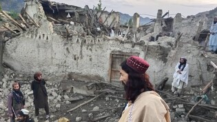 HANDOUT - Auf diesem von der staatlichen Nachrichtenagentur Bakhtar veröffentlichten Foto betrachten Afghanen die Zerstörung durch ein Erdbeben in der ostafghanischen Provinz Paktika. Foto: Uncredited/Bakhtar News Agency/AP/dpa - ACHTUNG: Nur zur…
