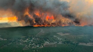 HANDOUT - Dieses von der Feuerwehr der Region Gironde SDIS 33 herausgegebene Foto zeigt Flammen und Rauch, die von einem Waldgebiet bei einem Waldbrand in Saint Magne, südlich von Bordeaux, im Südwesten Frankreichs, aufsteigen. Foto: Uncredited/SDIS 33…