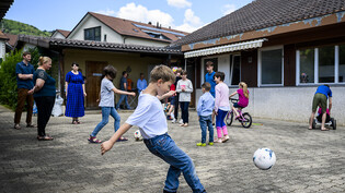 Aus der Ukraine geflüchtete Kinder spielen im Hof des Hauses in Gilly (VD), in dem sie untergebracht sind. Insgesamt leben dort drei Familien mit 25 Kindern und fünf Erwachsenen. (Archiv)