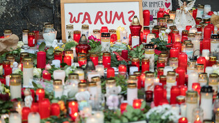 ARCHIV - Vor der Porta Nigra in Trier stellten Menschen zum Gedenken an die Opfer einer Amokfahrt Kerzen auf. Foto: Oliver Dietze/dpa/Archiv