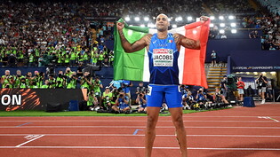Der Italiener Marcell Jacobs posiert nach dem Triumph über 100 m mit der italienischen Flagge