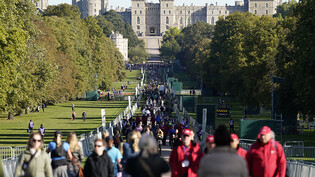 Zahlreiche Menschen sind während der Aufbahrung von Königin Elizabeth II. im Park vor Schloß Windsor unterwegs. Mehr als 250 000 Menschen haben der verstorbenen Königin an ihrem Sarg ihren Respekt gezollt. Foto: Andrew Matthews/PA Wire/dpa