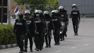 ARCHIV - Thailändische Polizeikräfte patrouillieren vor dem Regierungsgebäude in Bangkok (Symbolbild). Foto: Sakchai Lalit/AP/dpa