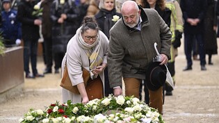 Menschen gedenken an einem Kranz während einer Zeremonie den Opfern. Foto: Laurie Dieffembacq/Belga/dpa