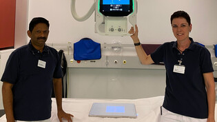 Sabina Jost (Radiologiefachfrau und Leiterin Radiologie) und Sonny Peter Thevalakattu (Radiologie­fachmann) präsentieren die neue Röntgenanlage im Spital Davos.