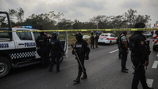 ARCHIV - Polizisten und Militärangehörige sichern das Gebiet, in dem es zu einer schweren bewaffneten Auseinandersetzung kam. Foto: Felix Marquez/dpa