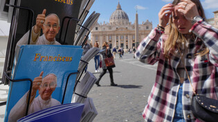 Auf dem Petersplatz in Rom werden Postkarten von Papst Franziskus verkauft.