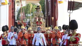 Der neu gekrönte thailändische König Maha Vajiralongkorn wird von seiner königlichen Garde auf einer Sänfte durch die Strassen der Hauptstadt Bangkok getragen.