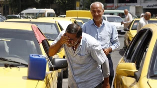 Ein Taxifahrer in der iranischen Hauptstadt Teheran spritzt sich zur Erfrischung Wasser ins Gesicht. (Archivbild)