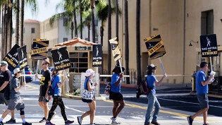 Als Zeichen der Solidarität schließen sich Drehbuchautoren den Streikenden der SAG-AFTRA vor den Toren der Warner Bros. Studios in Los Angeles an. Foto: Richard Vogel/AP