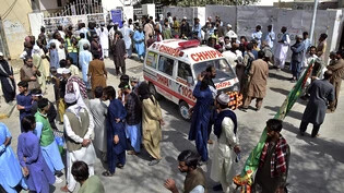 Menschen versammeln sich vor einem Krankenhaus, wo viele Verletzte nach einem Anschlag vor einer Moschee hingebracht wurden. Im Südwesten Pakistans sind bei einem Selbstmordanschlag während einer religiösen Veranstaltung Menschen ums Leben gekommen. Foto…
