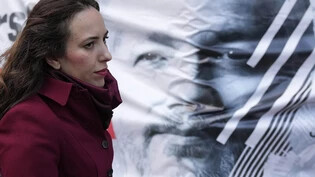 ARCHIV - Stella Assange, Ehefrau des Wikileaks-Gründers Julian Assange, der im Hintergrund auf einem Plakat zu sehen ist, verlässt den High Court in London. Foto: Frank Augstein/AP/dpa