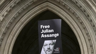 Ein Transparent, mit dem Konterfei von WikiLeaks-Gründer, Julian Assange, vor dem Royal Courts of Justice in London. Foto: Kirsty Wigglesworth/AP/dpa