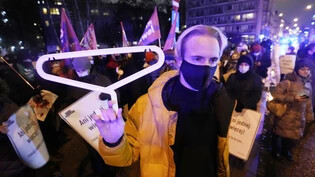 ARCHIV - Ein Demonstrant hält einen Kleiderbügel, ein Symbol für gefährliche illegale Schwangerschaftsabbrüche, während einer Demonstration vor dem polnischen Parlament. Das mitregierende Linksbündnis Lewica hat für eine Entkriminalisierung von…
