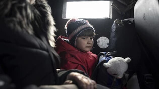 ARCHIV - Dieses von der Nachrichtenagentur AP am 21.03.2023 zur Verfügung gestellte Foto zeigt ein Mädchen, das mit seiner Mutter während der Evakuierung in einem Fahrzeug sitzt. Foto: Evgeniy Maloletka/AP/dpa