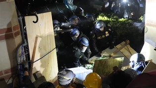 Die Polizei durchbricht eine Absperrung, die von pro-palästinensischen Demonstranten auf dem UCLA-Campus errichtet wurde. Foto: Jae C. Hong/AP/dpa