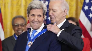 US-Präsident Joe Biden verleiht die höchste zivile Auszeichnung der Nation, die Presidential Medal of Freedom, an den ehemaligen US-Außenminister John Kerry während einer Zeremonie im East Room des Weißen Hauses. Foto: Alex Brandon/AP/dpa