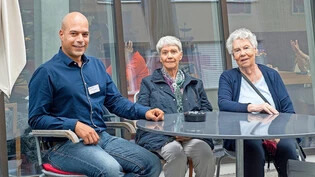 Zuversichtlich: Emanuele Forte, Leiter der Alterssiedlung Bodmer, mit Mieterinnen Klara Küenzle und Irma Caduff vor dem Café, das seit Kurzem wieder offen ist.