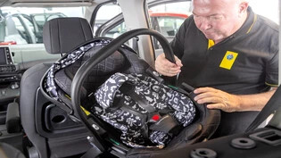 Unter die Lupe genommen: Ein Experte baut einen Kindersitz probehalber im Fond eines Fahrzeuges ein
