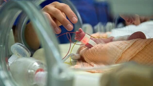 In guten Händen: Ein neugeborenes Baby liegt auf der Kinderintensivstation im Kantonsspital in Chur. Das Spital befürchtet, dass die Abteilung geschlossen wird.
