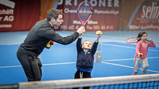 So schlägt man auf: Walter Iten zeigt einem Jungen den richtigen Umgang mit dem Tennisschläger.
