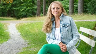 In der Natur: Mentaltrainerin Rita Sutter sitzt auf einer Bank.